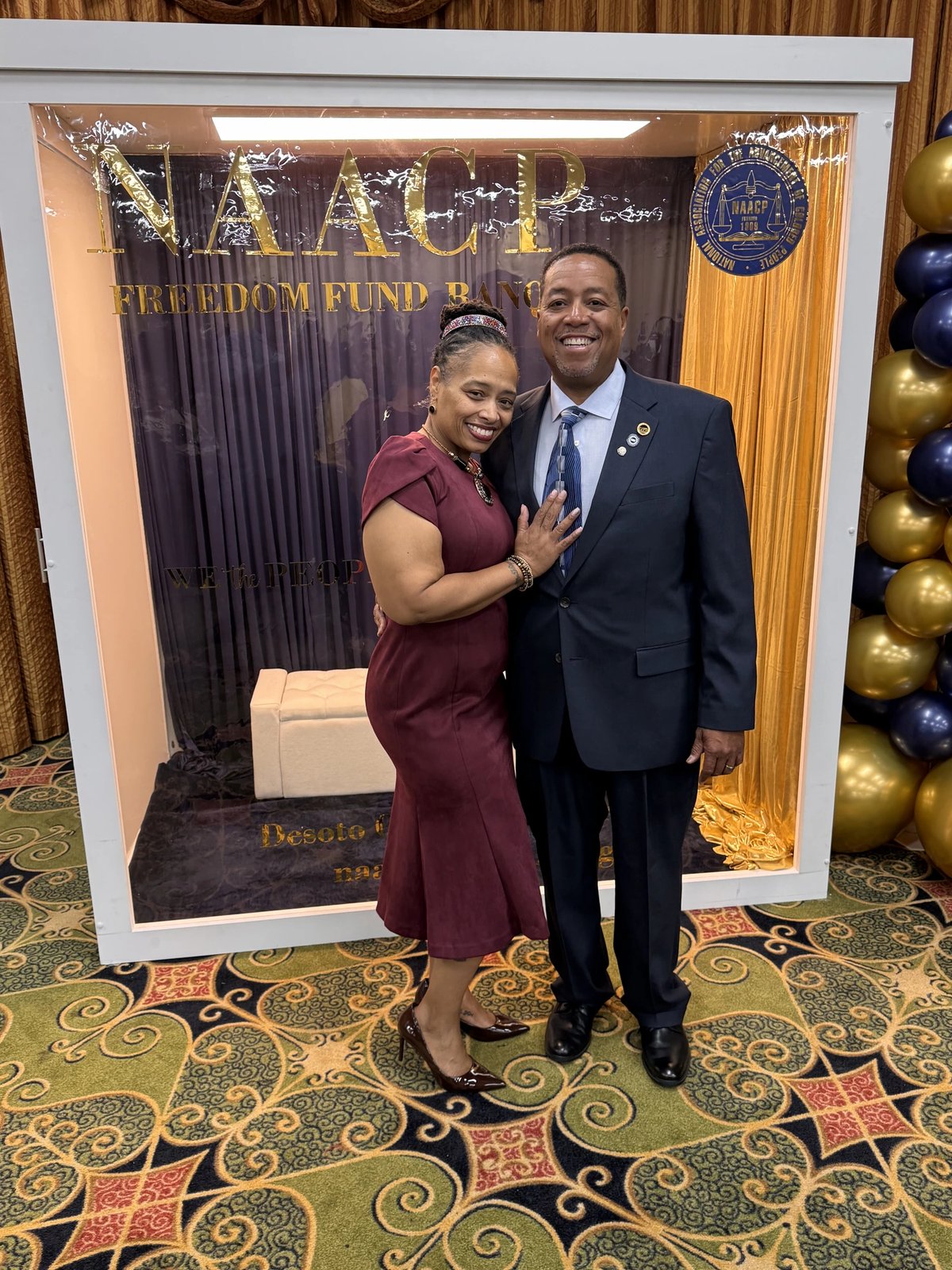 A couple posed in front of the DeSoto County NAACP Freedom Fund Banquet photo frame